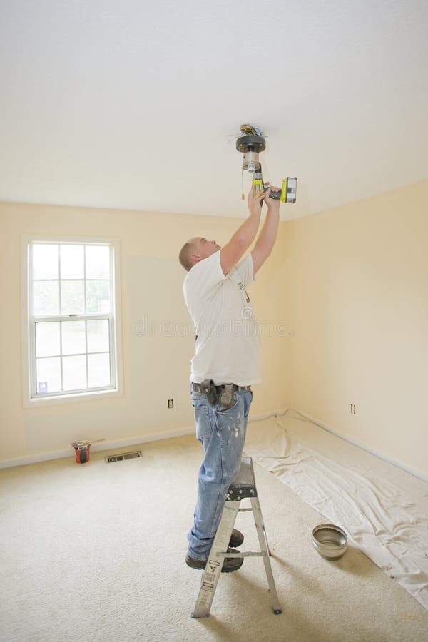 Electrician installing new light fixture and fan in bedroom for home that is going to be sold. Home electrician stock images, royalty-free photos and pictures