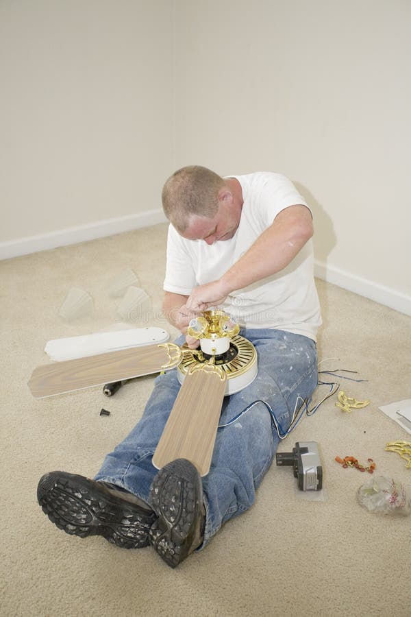 Electrician installing new light fixture and fan in home that is going on the market forsale. Home electrician stock images, royalty-free photos and pictures