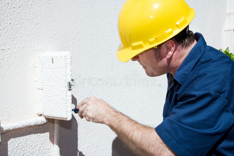 Electrician doing repairs inside and electrical box on the outside of a home. Model is a licensed electrician and all work is being performed according to industry code and safety standards. Home electrician stock images, royalty-free photos and pictures