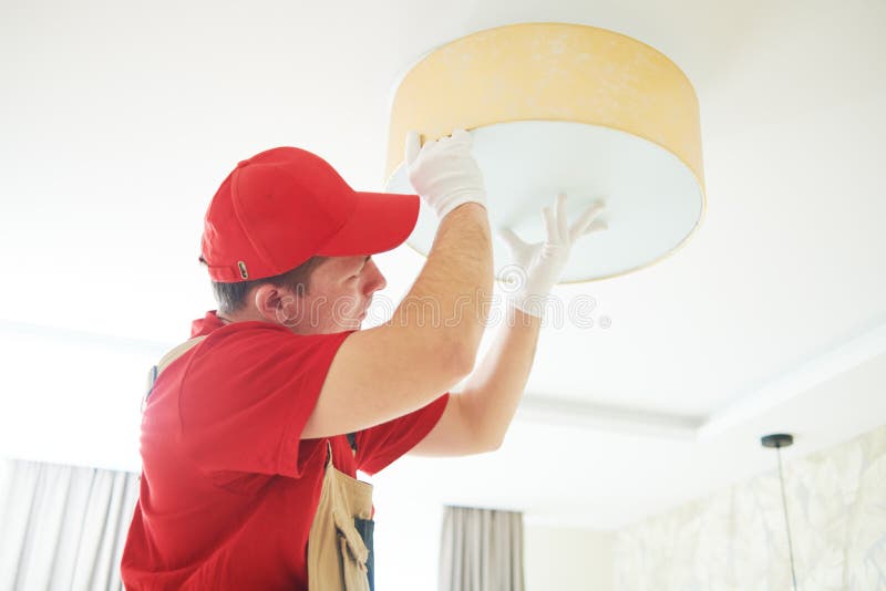Electrician works with ceiling lamp. installing or repair service stock images Electrician works with ceiling lamp. installing or repair service stock images