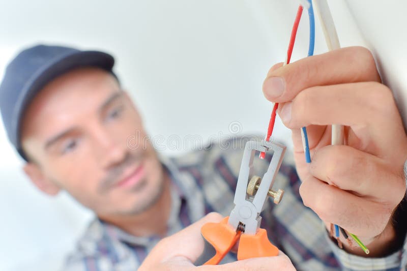 Electricista que corta un alambre