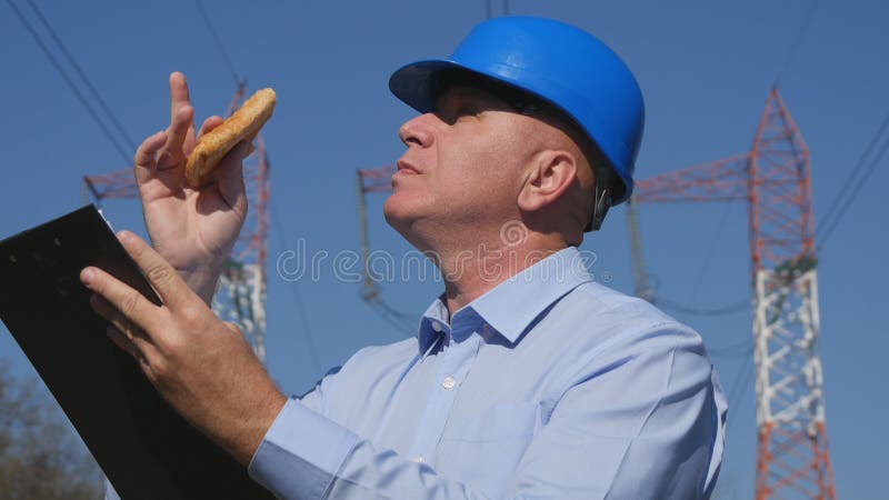 Electricista Working del ingeniero en tiempo de desayuno imagen de archivo libre de regalías Electricista Working del ingeniero en tiempo de desayuno imagen de archivo libre de regalías