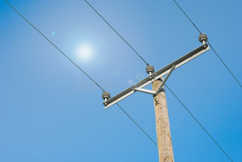 Electricity pole and cable on blue sky and sun ba