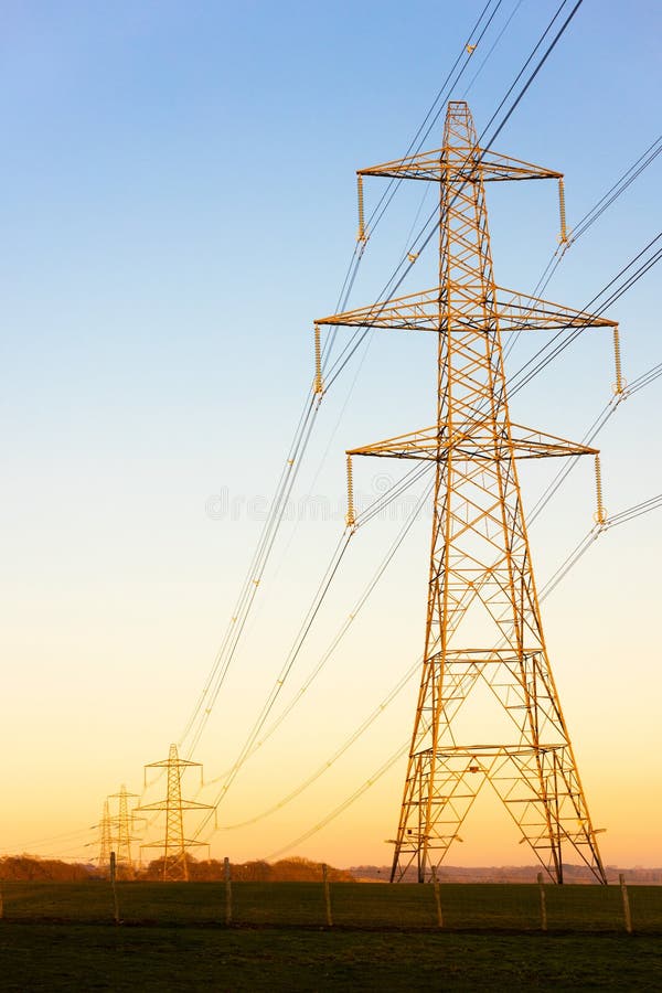 Electricity Pylons of the National Grid at Sunset or Sunrise Stock
