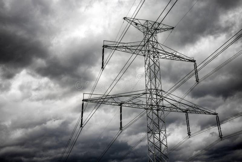 Electricity Transmission Power Lines and Dark Clouds on Sky Stock Image