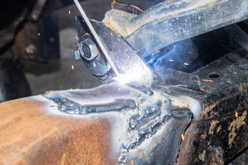 Welding Man Welding Car Chassis in Garage by Electric Welding Torch in