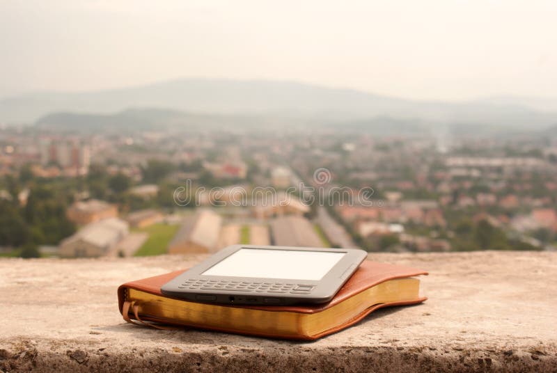 Electronic book reader laying on the book