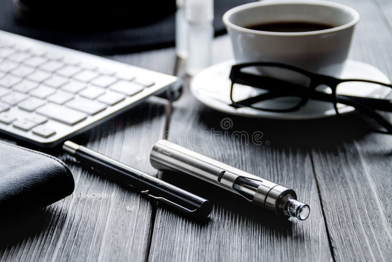 Electronic cigarettes and mens dark wooden desktop