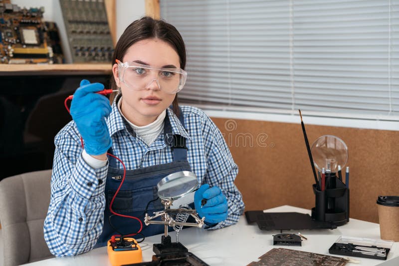 Electronic technician working in service center. Woman repairman working on fixing hardware in computer workshop. stock photos