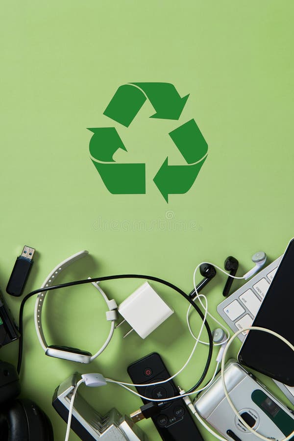 Electronic waste, old gadgets, and devices clustered below a prominent green recycling symbol on a p stock photos