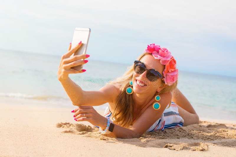 Elegancka młoda ładna kobieta bierze selfie na plaży obraz stock Elegancka młoda ładna kobieta bierze selfie na plaży obraz stock