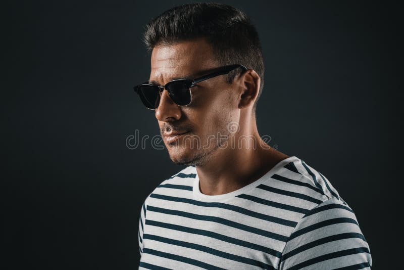 Elegancki mężczyzna w pasiastej koszulce i okularach przeciwsłonecznych odizolowywających na popielatym, fotografia royalty free Elegancki mężczyzna w pasiastej koszulce i okularach przeciwsłonecznych odizolowywających na popielatym, fotografia royalty free