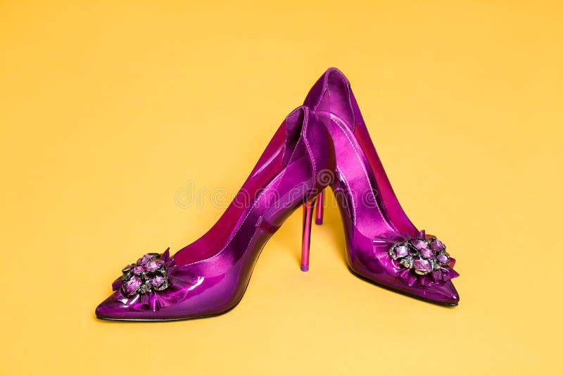 Eleganckich kobiet ` s buty z szpilki i splendoru dekoracjami na żółtym tle zdjęcia stock Eleganckich kobiet ` s buty z szpilki i splendoru dekoracjami na żółtym tle zdjęcia stock