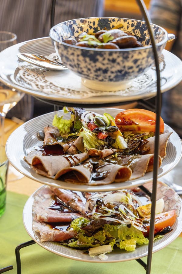 Elegant appetizer presentation on a three tiered serving stand, featuring roast beef, ham, salad, and mushrooms stock photography