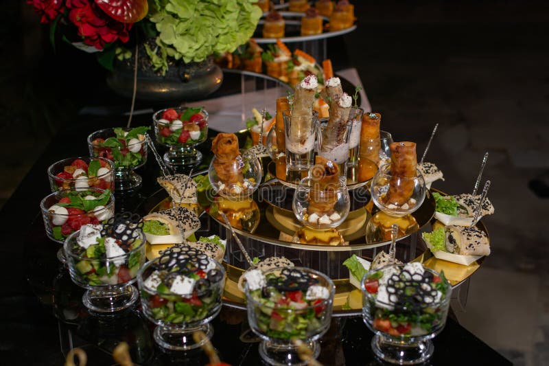 Elegant appetizers including salads, vegetable spring rolls, and caprese are presented on a formal catering buffet display at an royalty free stock photography