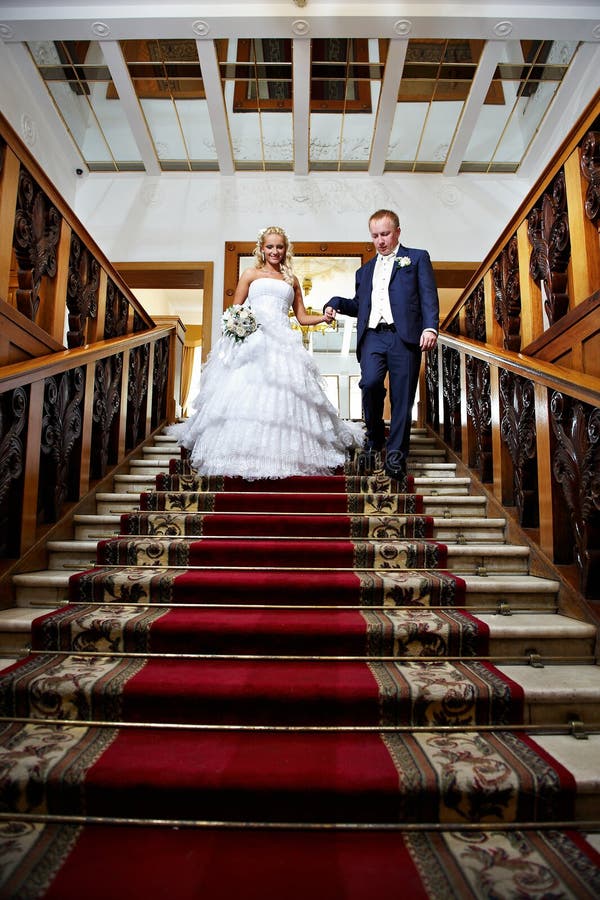 Elegant bride and groom in stairs with red carpet