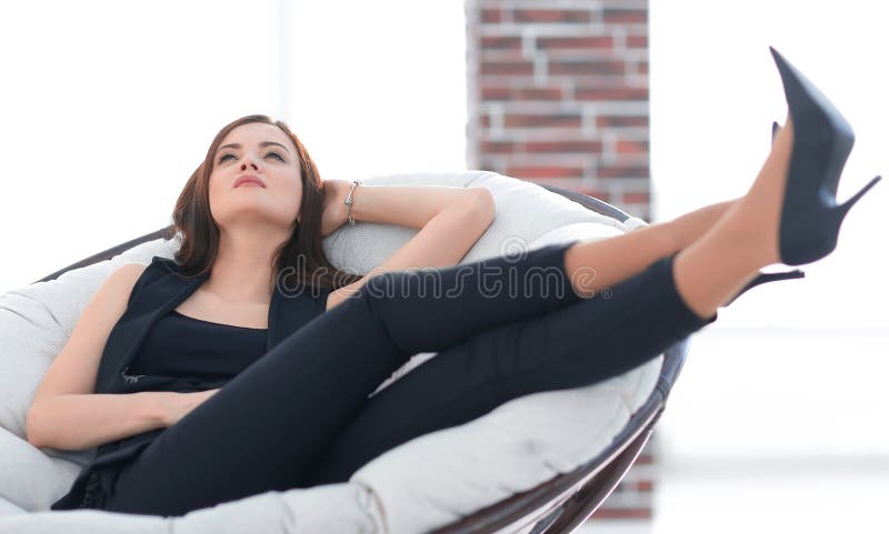 Elegant business woman sitting in a comfortable chair.