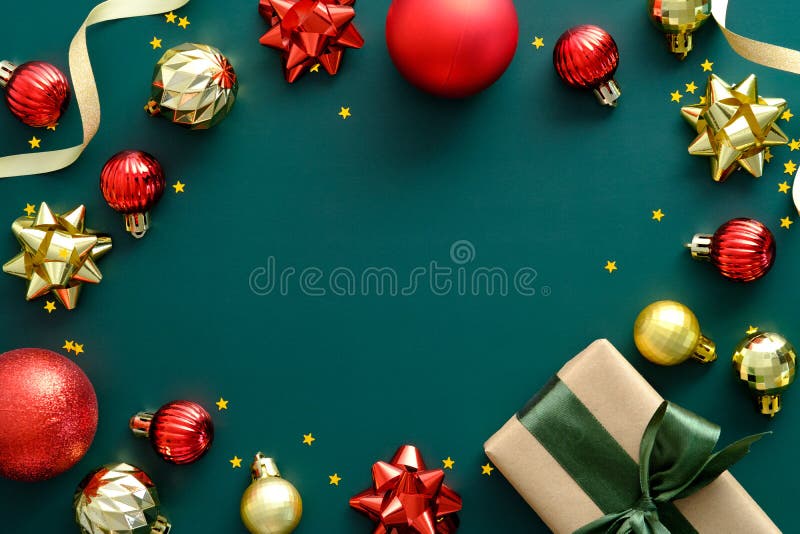 Elegant Christmas composition with red and golden balls, gift box, confetti on green background. Vintage style. Christmas banner