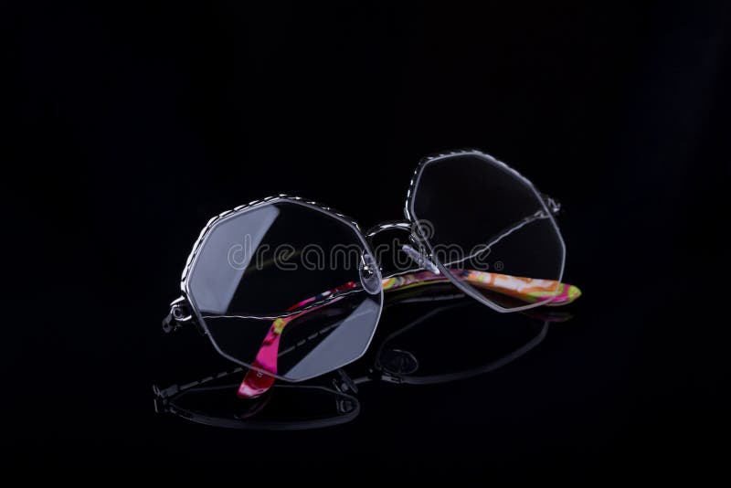 Elegant glasses on a black background with a mirror image.