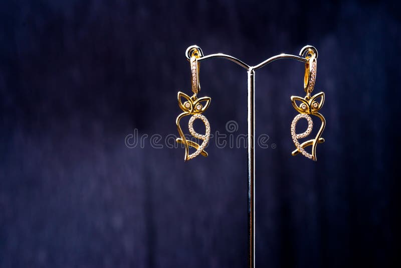 Elegant gold earrings with intricate design. royalty free stock photography