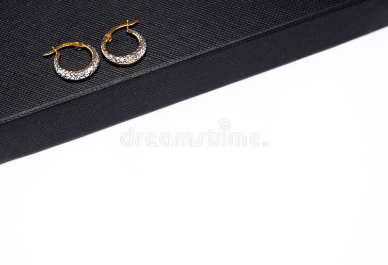 Elegant gold and silver hoop earrings on black. stock photos