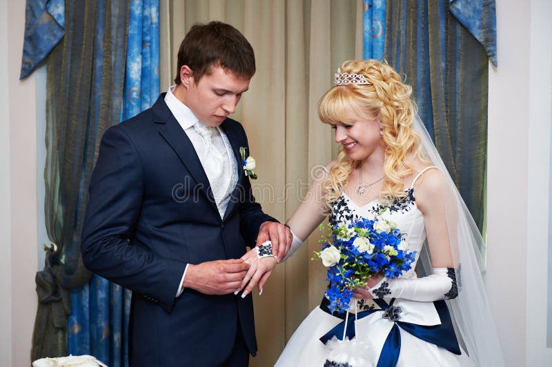 Elegant groom wears wedding ring happy bride