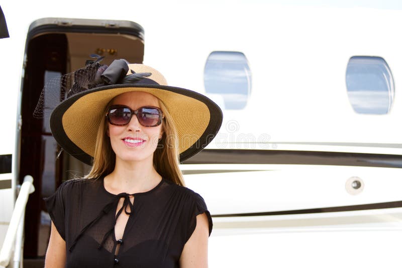 Elegant lady standing by jet plane stock images
