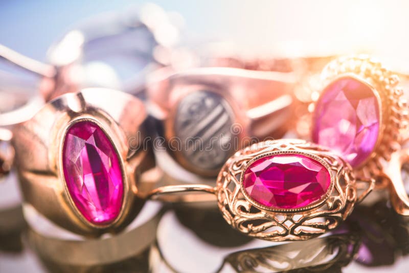 Elegant lyxig sammansättning av guld- smycken med cirkeln med röd ametist och rubingemstone och diamanter på ljus bakgrundsnärbil royaltyfria foton