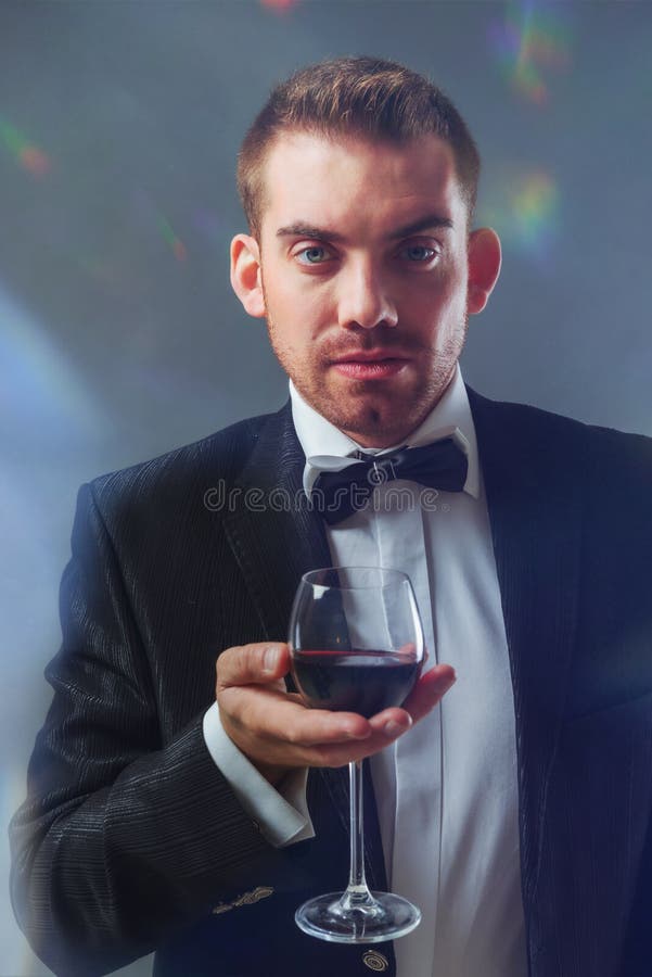 Elegant man holding a glass of red wine