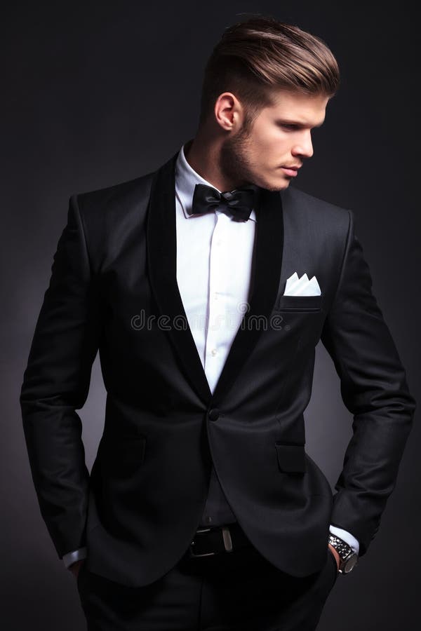 Elegant man looks to side with hands in pockets royalty free stock photo