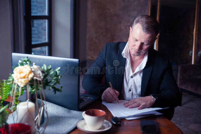 Elegant man signs papers in luxury apartments stock image Elegant man signs papers in luxury apartments stock image