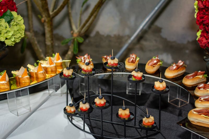Elegant mini fruit and meat canapés are presented on a formal catering buffet display for an evening event royalty free stock photo