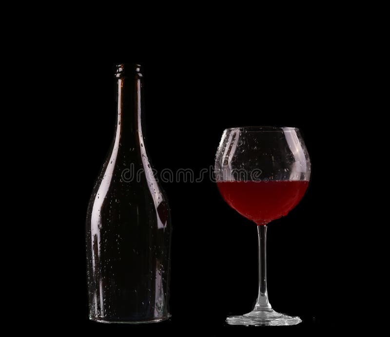 Elegant rode wijnglas en een wijnfles in zwarte royalty-vrije stock afbeeldingen Elegant rode wijnglas en een wijnfles in zwarte royalty-vrije stock afbeeldingen