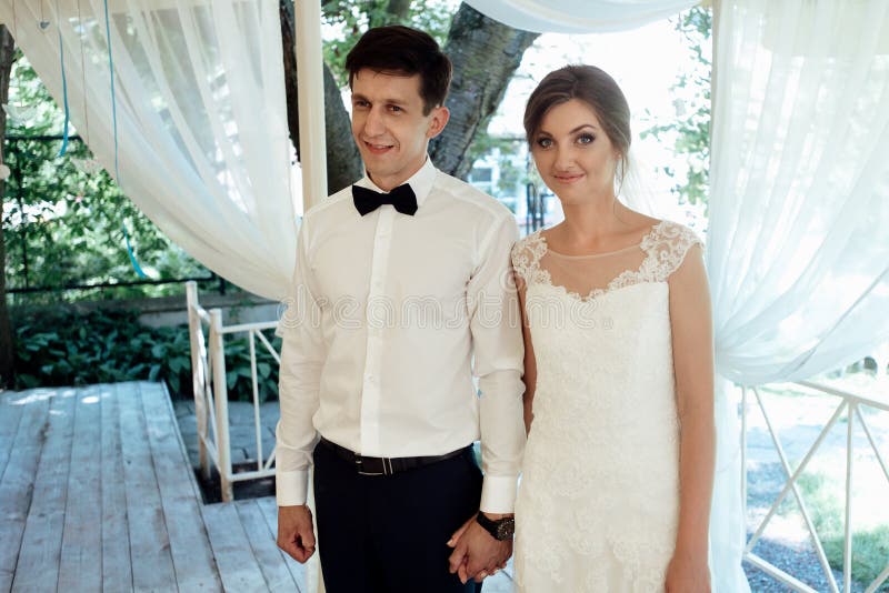 Elegant stilfull brudgum och lycklig ursnygg brud som rostar på wedd royaltyfri fotografi Elegant stilfull brudgum och lycklig ursnygg brud som rostar på wedd royaltyfri fotografi