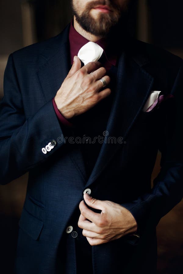 Elegant stilfull stilig brudgum som får klar i morgon holding royaltyfri bild Elegant stilfull stilig brudgum som får klar i morgon holding royaltyfri bild