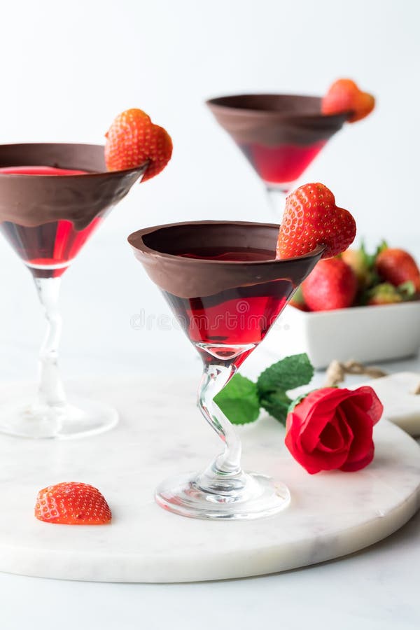 Elegant Valentine&x27;s Day cocktails garnished with heart shaped strawberries.