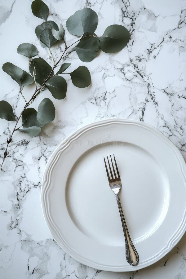 Elegant white plate with a fork and eucalyptus branch on marble background stock photos