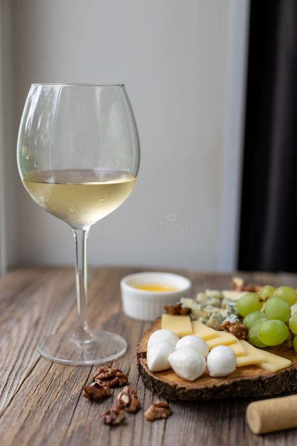 Elegant wine and cheese board with grapes and nuts on rustic wooden table stock photos