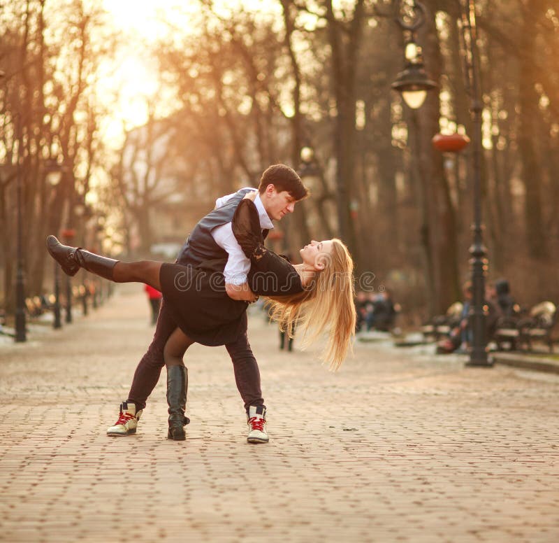 Elegant young couple in love in classic style passionately dancing in city park royalty free stock photography Elegant young couple in love in classic style passionately dancing in city park royalty free stock photography