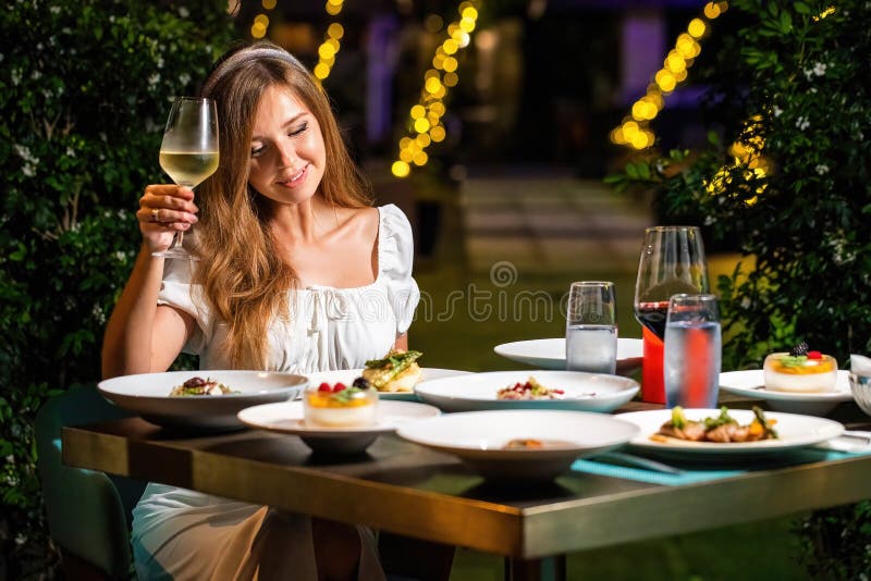 https://thumbs.dreamstime.com/b/elegant-young-woman-white-dress-enjoying-champagne-evening-dinner-luxury-restaurant-high-end-dining-experience-fine-266776282.jpg