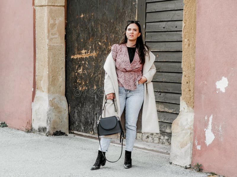 Elegante joven morena mujer de croacia posando para la cámara en frente de un viejo edificio rojo fotos de archivo libres de regalías