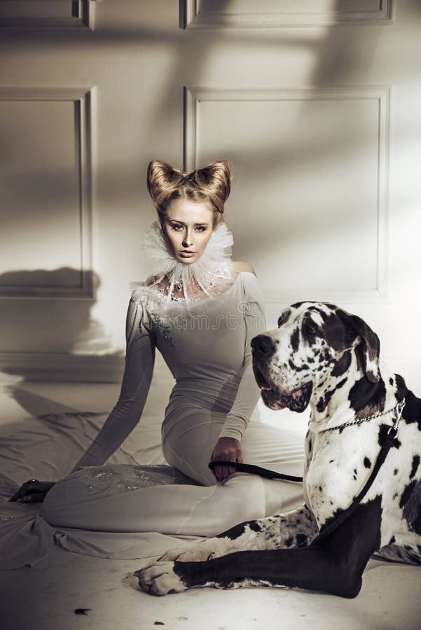 Elegante junge Dame, die mit ihrem freundlichen Hund sich entspannt lizenzfreie stockbilder Elegante junge Dame, die mit ihrem freundlichen Hund sich entspannt lizenzfreie stockbilder