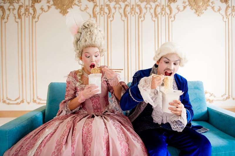 Elegante pareja con vintage que disfruta de una moderna y humorística adquisición en lujosos interiores de estilo baroquero foto de archivo
