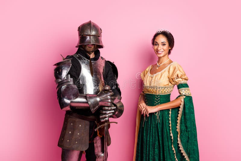 Elegante pareja medievalita con disfraz de caballero y princesa con fondo rosa fotos de archivo