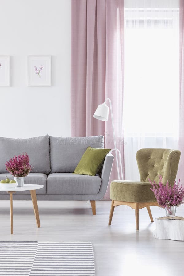 Elegante woonkamer met de grijze comfortabele groene leunstoel van de laagolijf en heide in metaalpotten royalty-vrije stock afbeelding Elegante woonkamer met de grijze comfortabele groene leunstoel van de laagolijf en heide in metaalpotten royalty-vrije stock afbeelding