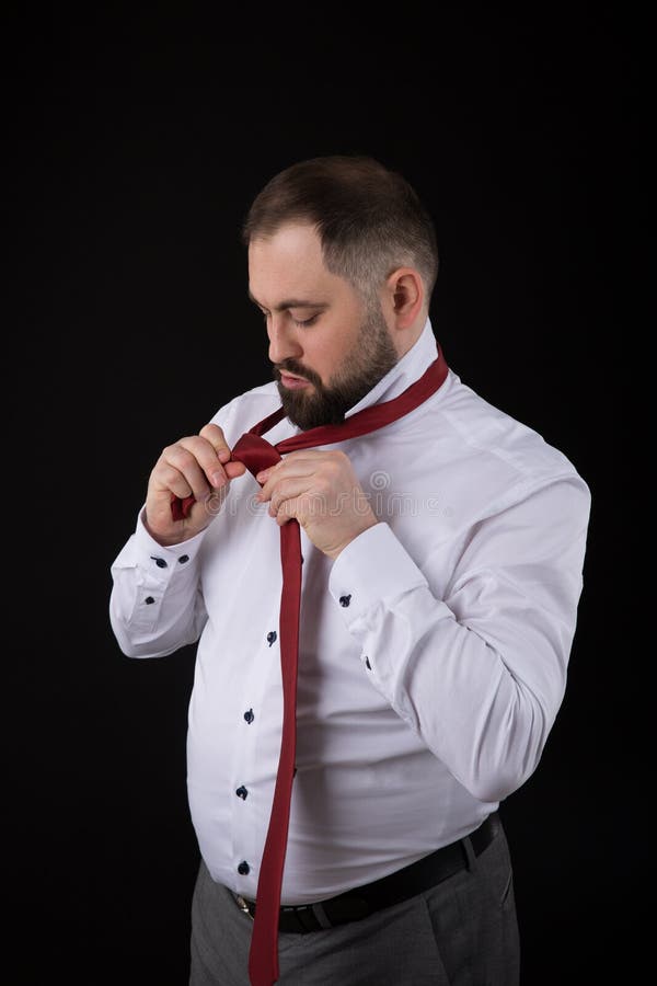 Eleganter Geschäftsmann in einem weißen Hemd, richtet Bindungen sein Bindung ob Schwarzhintergrund gerade stockfoto Eleganter Geschäftsmann in einem weißen Hemd, richtet Bindungen sein Bindung ob Schwarzhintergrund gerade stockfoto