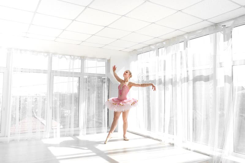 Eleganter weiblicher Balletttänzer im rosa übenden und lächelnden Ballettröckchen stockfotografie Eleganter weiblicher Balletttänzer im rosa übenden und lächelnden Ballettröckchen stockfotografie