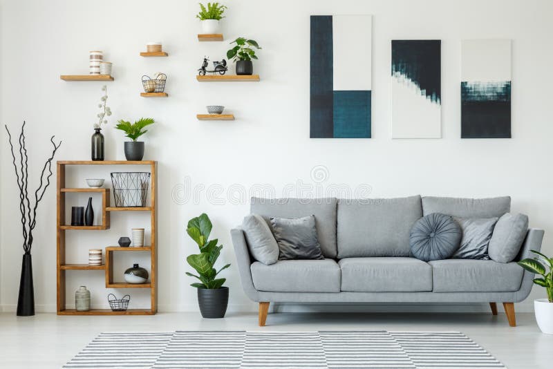 Eleganter Wohnzimmerinnenraum mit einem grauen Sofa, hölzerne Regale, p