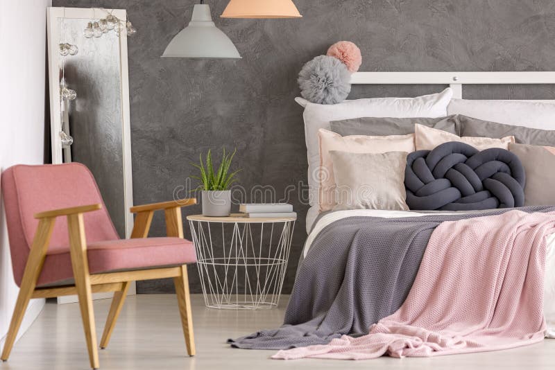 Elegant gray and pastel pink hotel bedroom interior with retro armchair and creative design decor. Elegant gray and pastel pink hotel bedroom interior with retro armchair and creative design decor