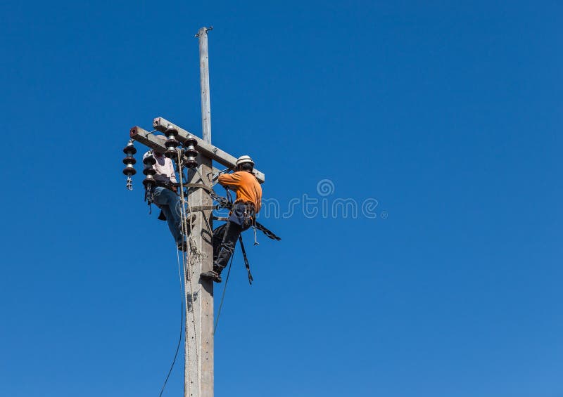 Elektriciens die het werk in de hoogte op concrete stroompool beklimmen royalty-vrije stock fotografie Elektriciens die het werk in de hoogte op concrete stroompool beklimmen royalty-vrije stock fotografie